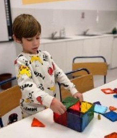 A child stacking blocks and tiles