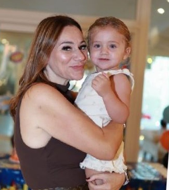 A member of the team holding a smiling toddler